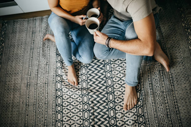 Couple sitting on floor and drinking coffee | JR Floors and Window Coverings